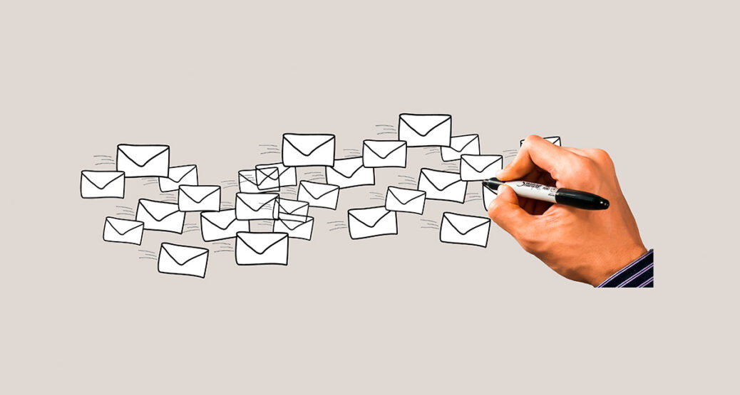 Käsi piirtää tussilla kirjekuorien kuvia.