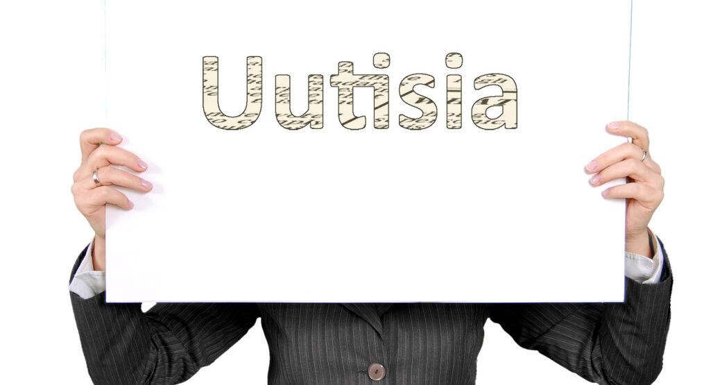 Henkilö näyttää kylttiä, jossa lukee "Uutisia".