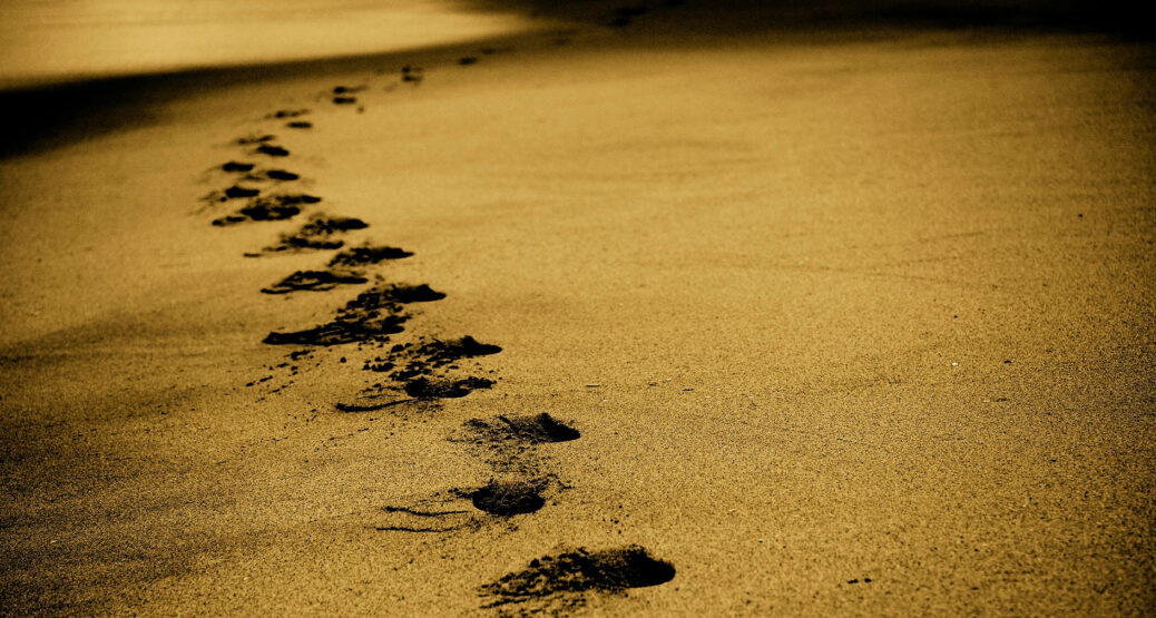 Jalanjäljet kulkevat hiekan poikki.
