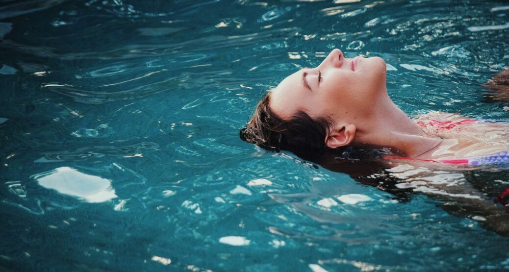 Henkilö kelluu vedessä rentoutuneena. Kuva: Haley Phelps/Unsplash.