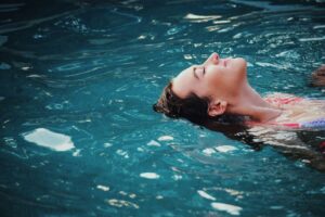 Henkilö kelluu vedessä rentoutuneena. Kuva: Haley Phelps/Unsplash.